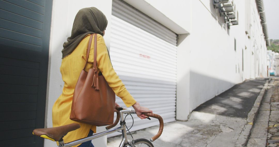 Muslim Woman with Bicycle Walking in Urban Street - Free Images, Stock Photos and Pictures on Pikwizard.com