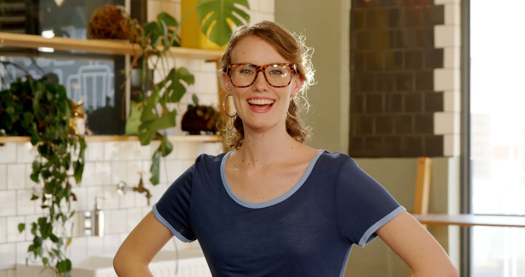 Cheerful Young Woman Wearing Eyeglasses Smiling in Modern Kitchen - Free Images, Stock Photos and Pictures on Pikwizard.com