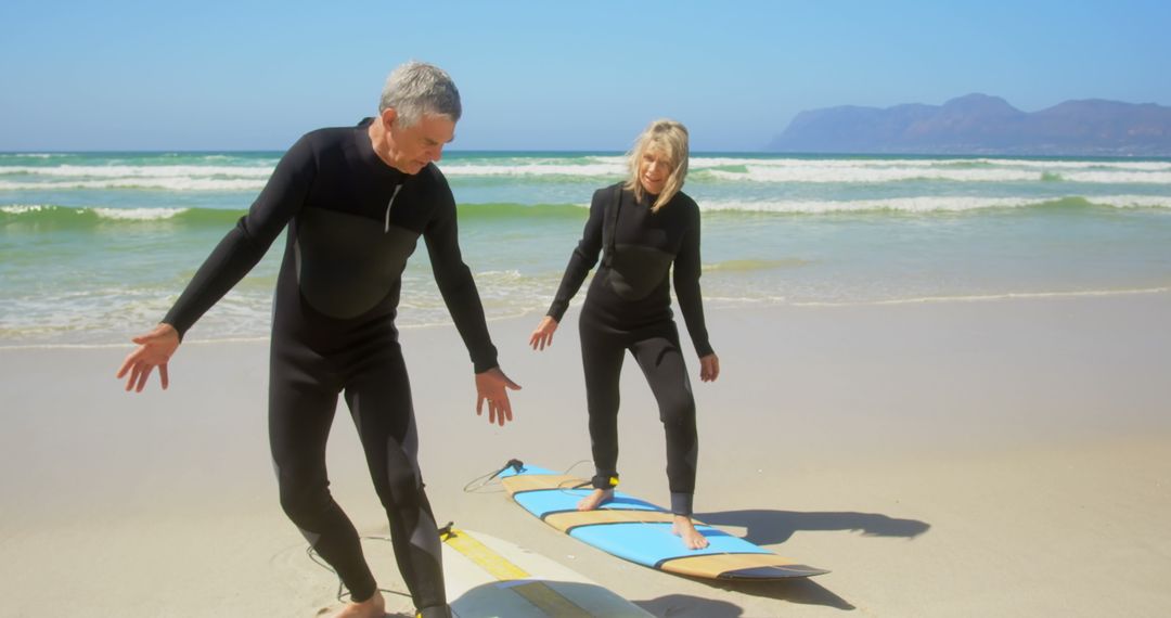 Senior Couple Practicing Surfing on Sunny Beach
