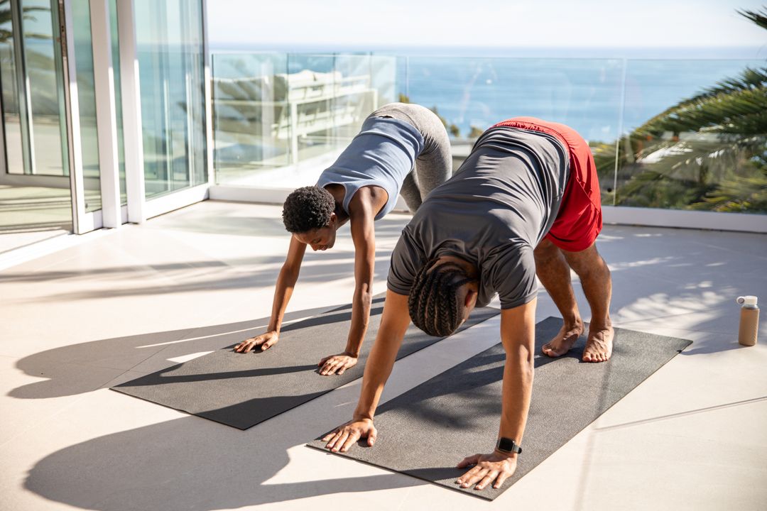Diverse Friends Practicing Yoga on Balcony with Stunning Ocean View