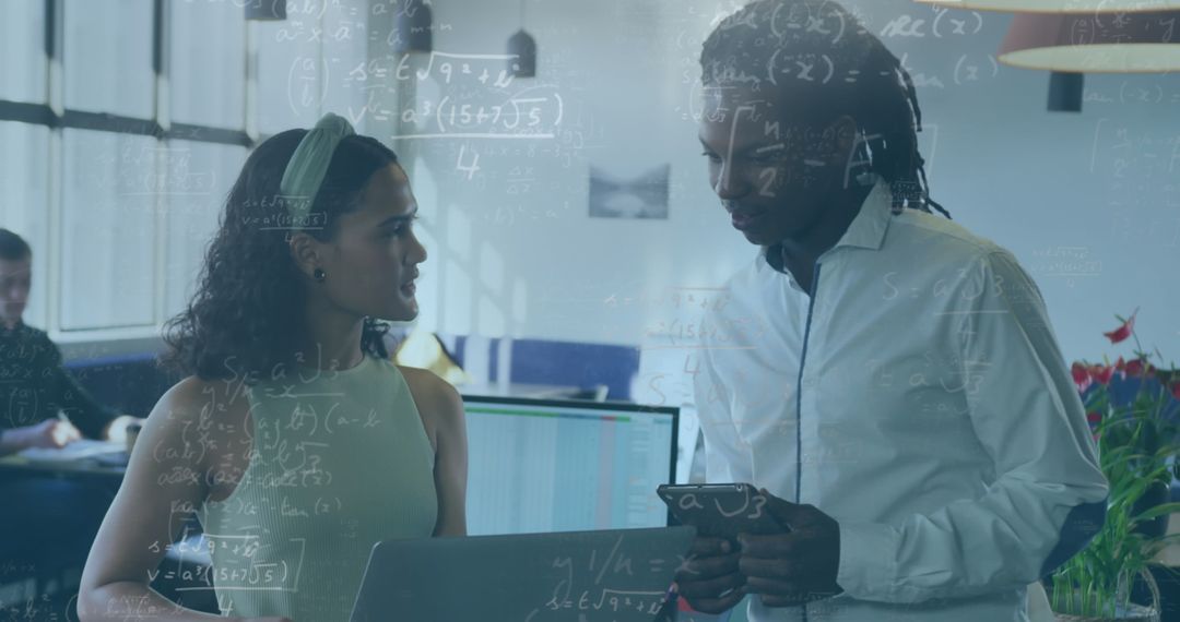 Coworkers Collaborating in Tech Office with Digital Devices