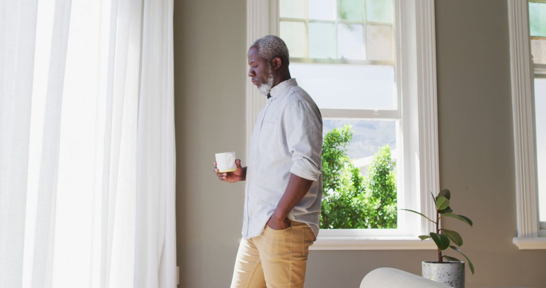 Thoughtful Man Relaxing with Coffee in Bright Living Room - Free Images, Stock Photos and Pictures on Pikwizard.com