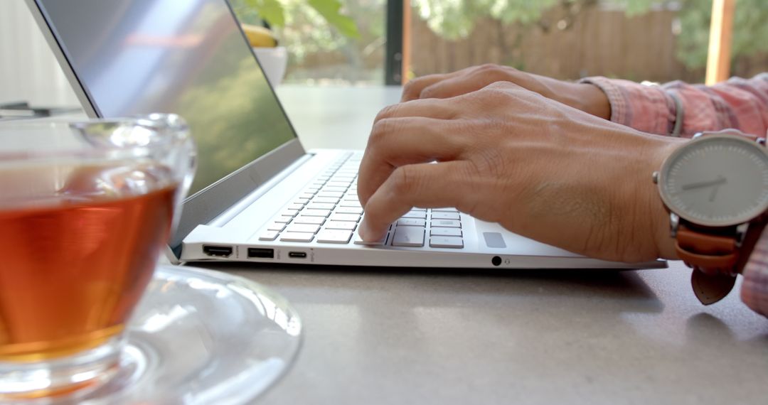 Freelancer Working on Laptop with Cup of Tea in Comfortable Home Office