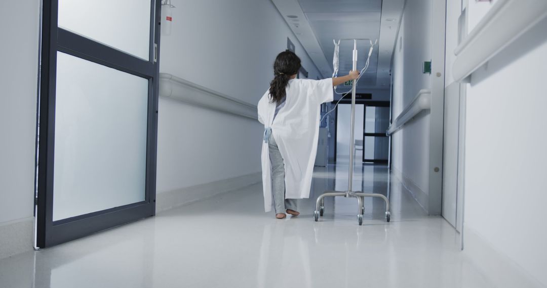 Young Patient Walking Hospital Hallway with IV Stand - Free Images, Stock Photos and Pictures on Pikwizard.com