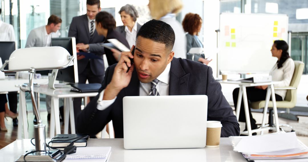 Busy Businessman Talking on Phone at Office Desk - Free Images, Stock Photos and Pictures on Pikwizard.com