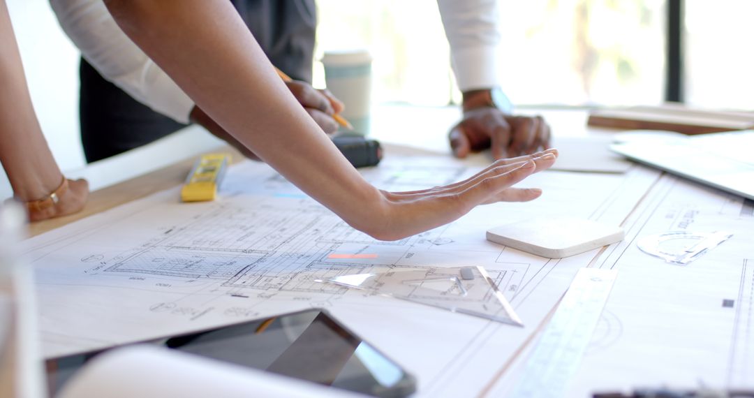 Team Collaborating Over Architectural Blueprints in Office