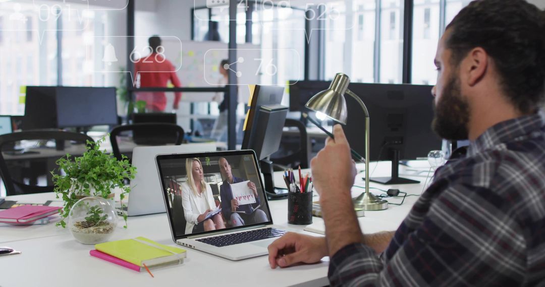 Man Gesturing During Video Conference in Modern Open-Plan Office Workspace