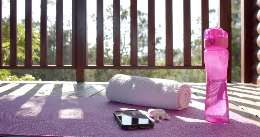 Yoga Mat with Water Bottle, Towel, and Earbuds on Balcony - Free Images, Stock Photos and Pictures on Pikwizard.com