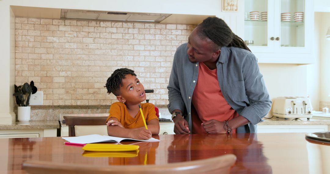 Father Helping Son with Homework in Kitchen Setting