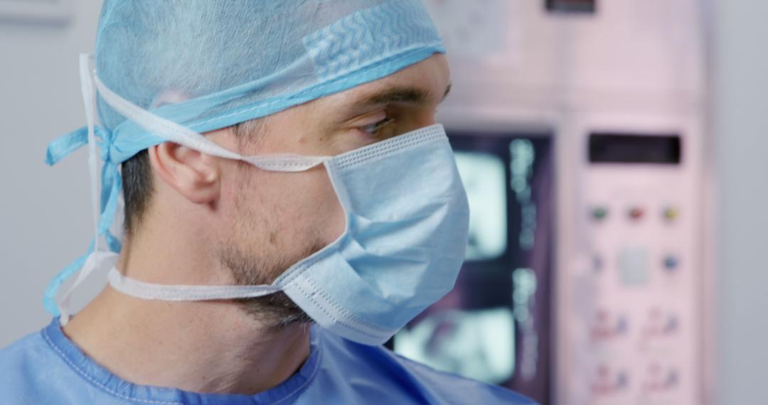 Surgeon in Surgical Mask and Cap Focuses in Operating Room - Free Images, Stock Photos and Pictures on Pikwizard.com