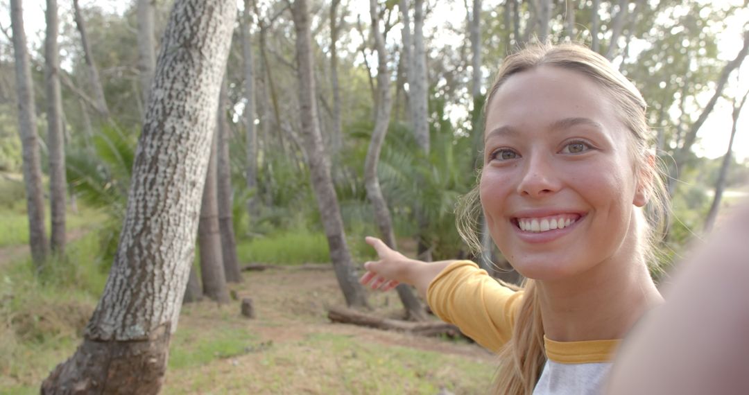 Smiling Woman Pointing at Scenery in Sunlit Forest