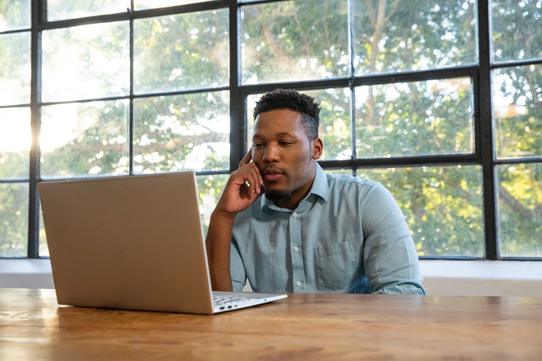 Focused Professional Working at Urban Home Office with Laptop