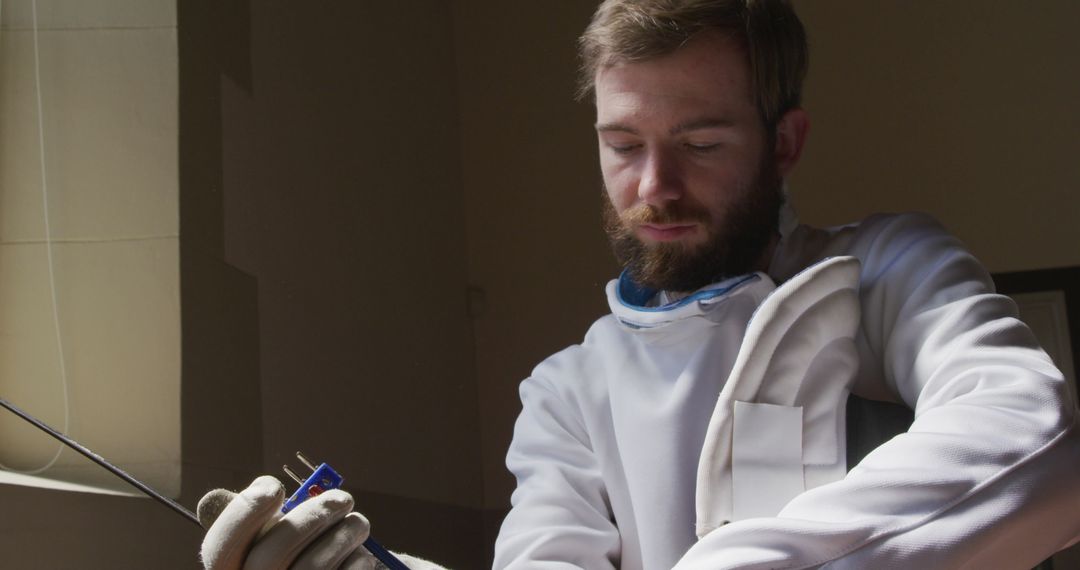 Focused Fencer Preparing for Duel in Training Center