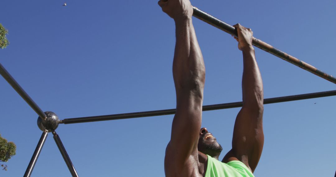 Man Performing Pull-up during Outdoor Workout under Clear Sky - Free Images, Stock Photos and Pictures on Pikwizard.com