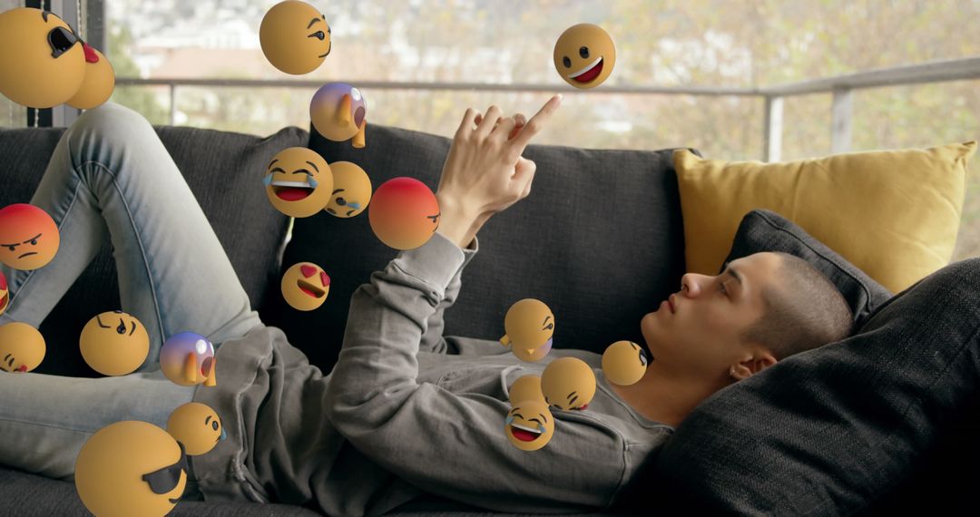 Young Man Interacting with Emojis on Smartphone while Relaxing