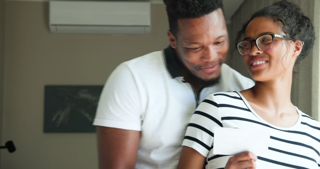 Expectant Couple Smiling While Viewing Sonogram at Home