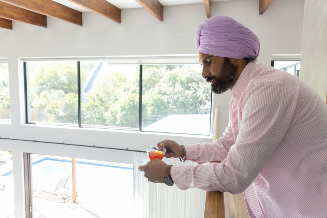Man in Traditional Attire Enjoying Tranquil Balcony View