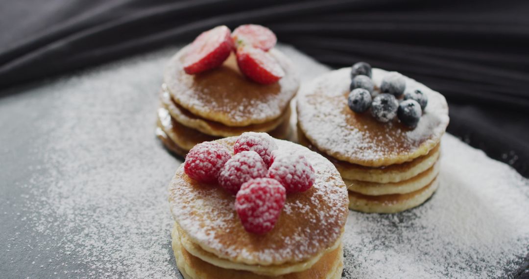 Delicious Pancakes Garnished with Fresh Berries and Powdered Sugar