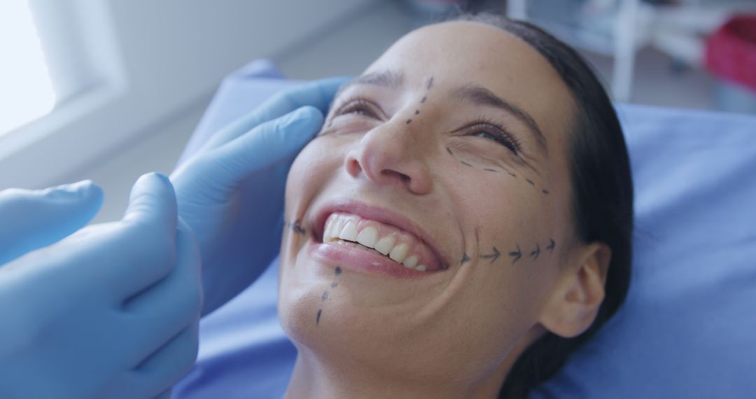 A smiling woman undergoes cosmetic surgery planning at a beauty clinic. - Free Images, Stock Photos and Pictures on Pikwizard.com
