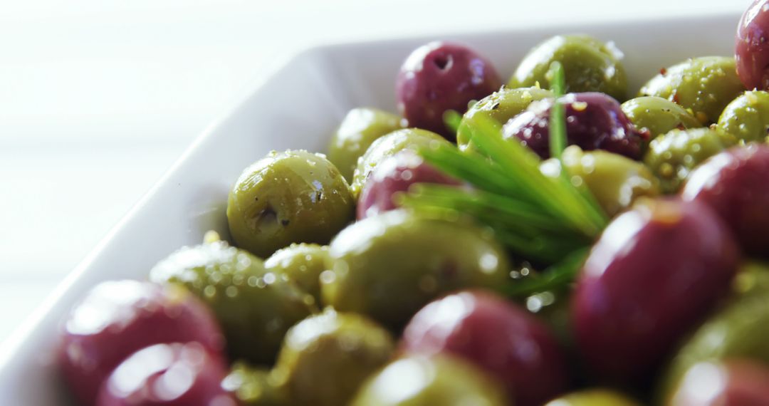 Colorful Assorted Olives with Rosemary in White Dish - Free Images, Stock Photos and Pictures on Pikwizard.com