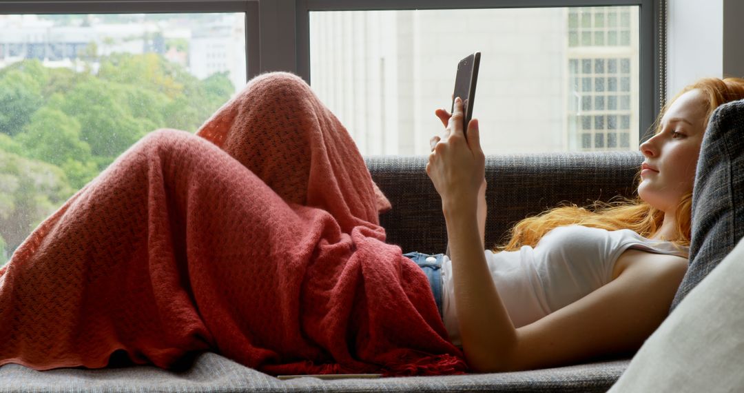 Young Woman Relaxing at Home with Smartphone During Leisure Day - Free Images, Stock Photos and Pictures on Pikwizard.com