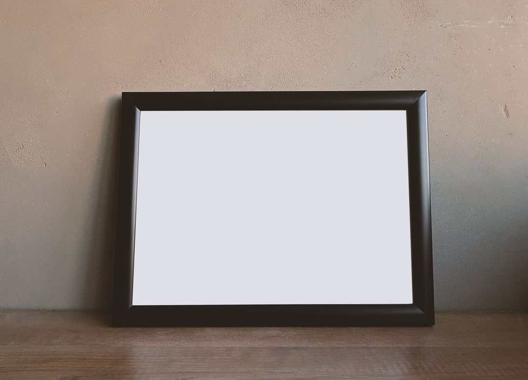 Empty Frame on Wooden Table with Concrete Wall Background