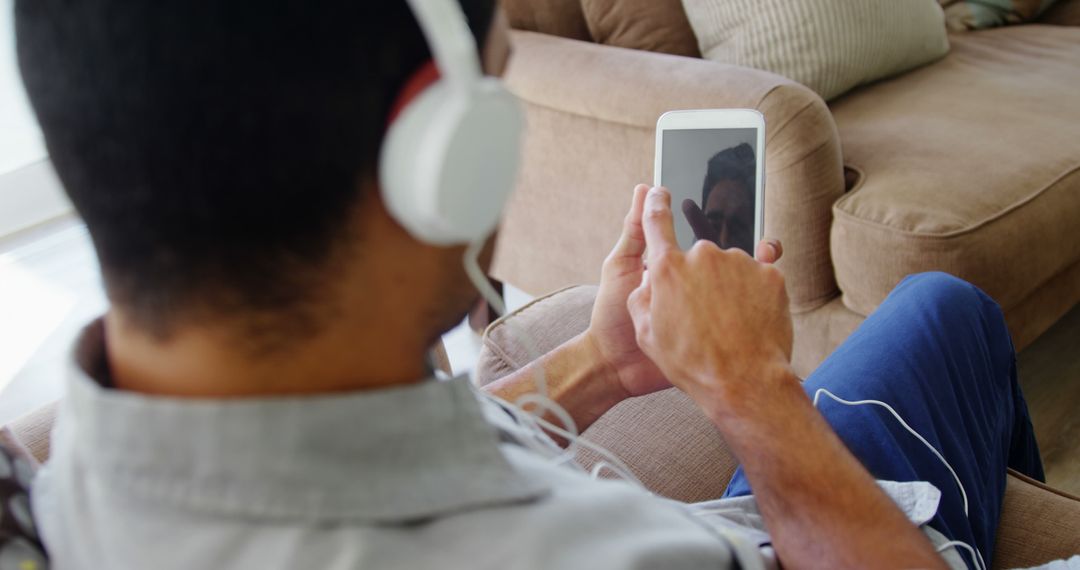 Man Relaxing on Couch Using Tablet and Headphones - Free Images, Stock Photos and Pictures on Pikwizard.com