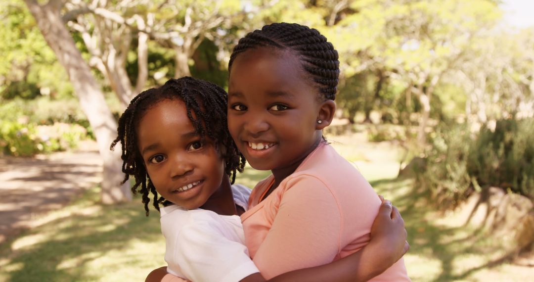 Two African American girls are sharing a joyful hug outdoors, with copy space - Free Images, Stock Photos and Pictures on Pikwizard.com