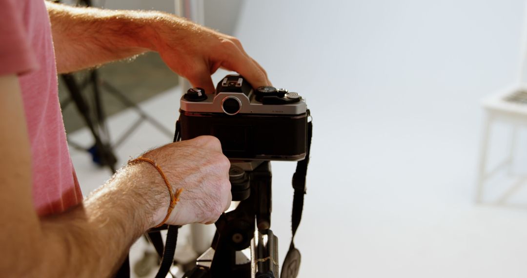 A Caucasian man adjusts a vintage camera on a tripod, with copy space - Free Images, Stock Photos and Pictures on Pikwizard.com