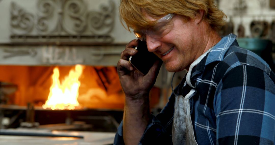 Portrait of Smiling Blacksmith Talking on Phone in Workshop - Free Images, Stock Photos and Pictures on Pikwizard.com