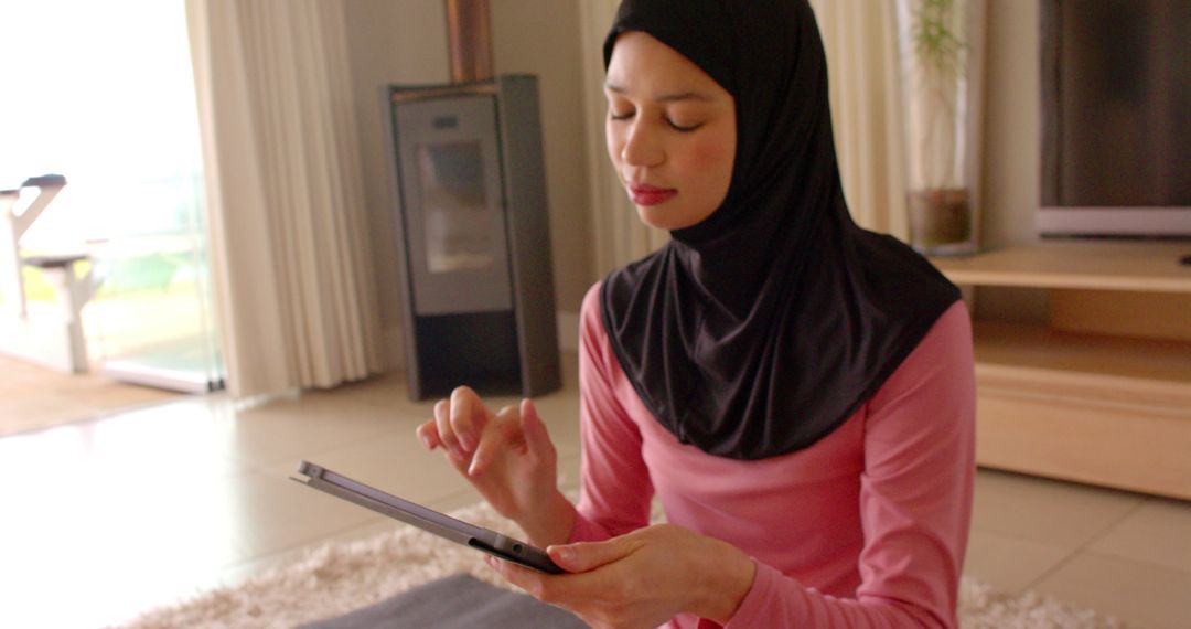 Woman in Hijab Using Tablet at Home for Relaxation - Free Images, Stock Photos and Pictures on Pikwizard.com