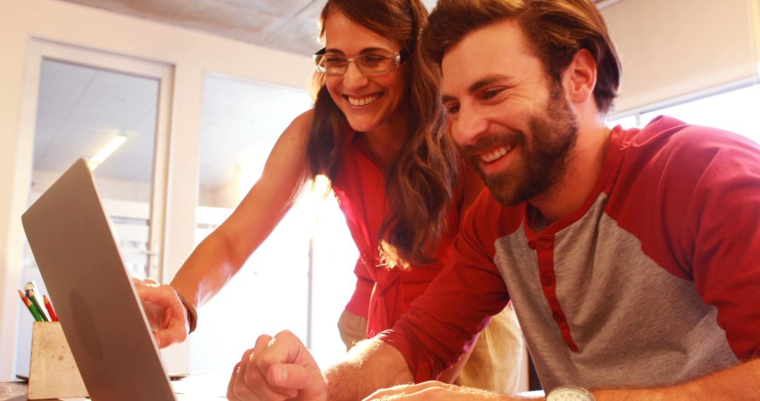 Creative Team Collaborating on Laptop in Modern Office Space