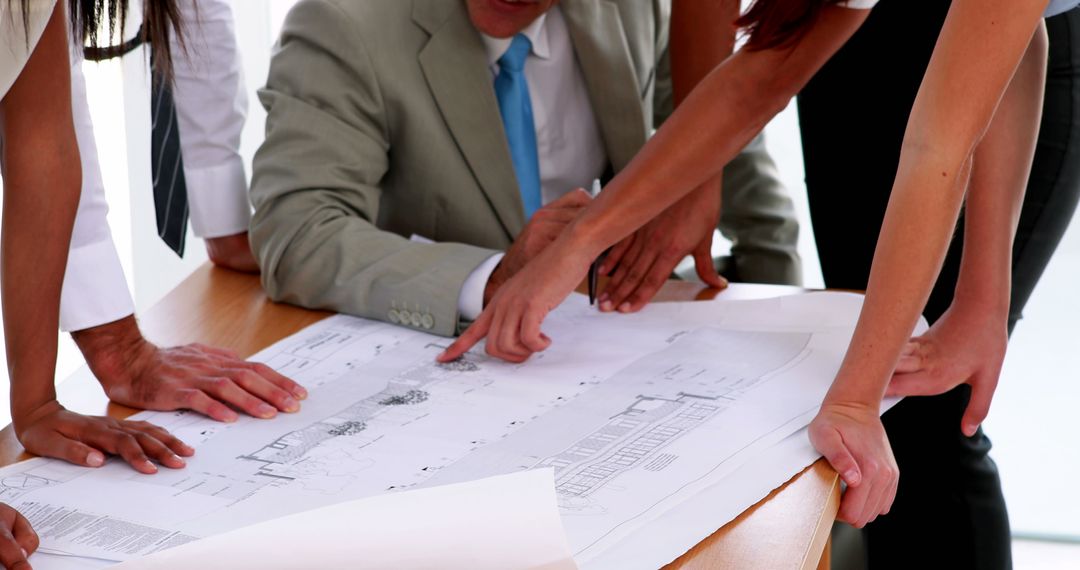 Business Team Discussing Architectural Blueprint at Meeting - Free Images, Stock Photos and Pictures on Pikwizard.com