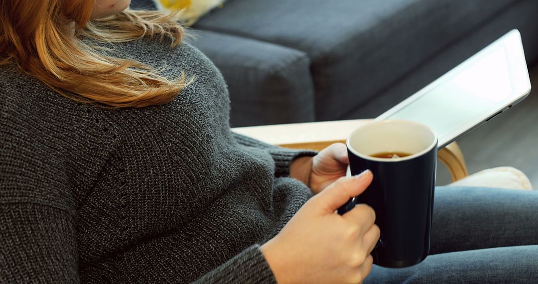 Woman Relaxing at Home with Hot Beverage and Tablet - Free Images, Stock Photos and Pictures on Pikwizard.com