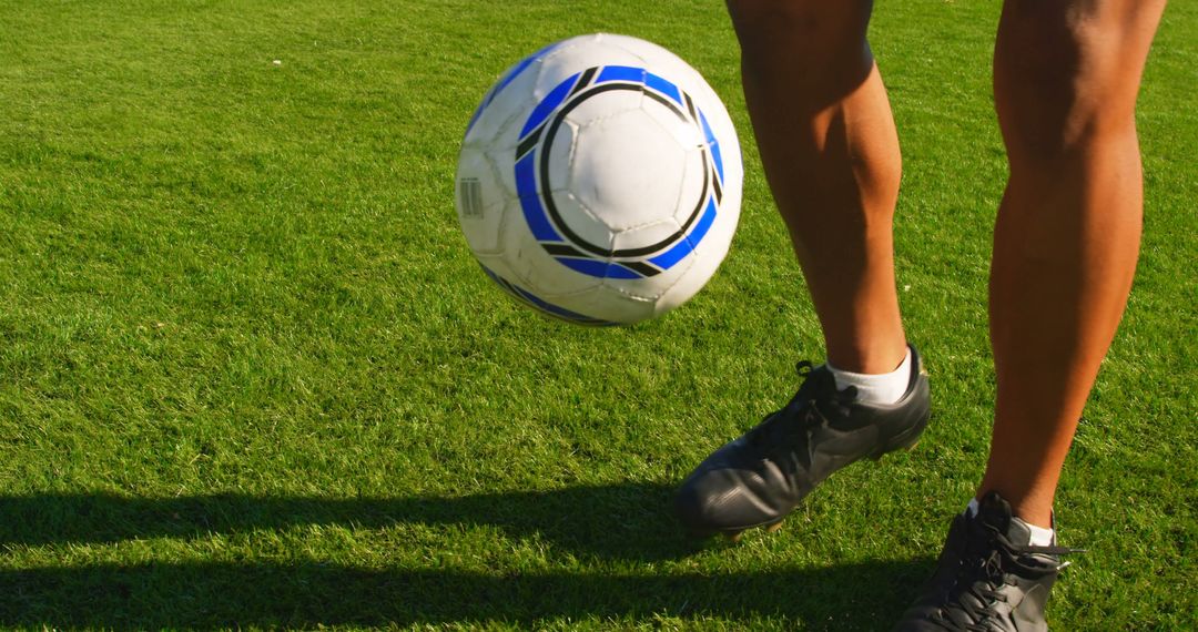 Soccer Player Kicking Ball on Grass Field - Free Images, Stock Photos and Pictures on Pikwizard.com