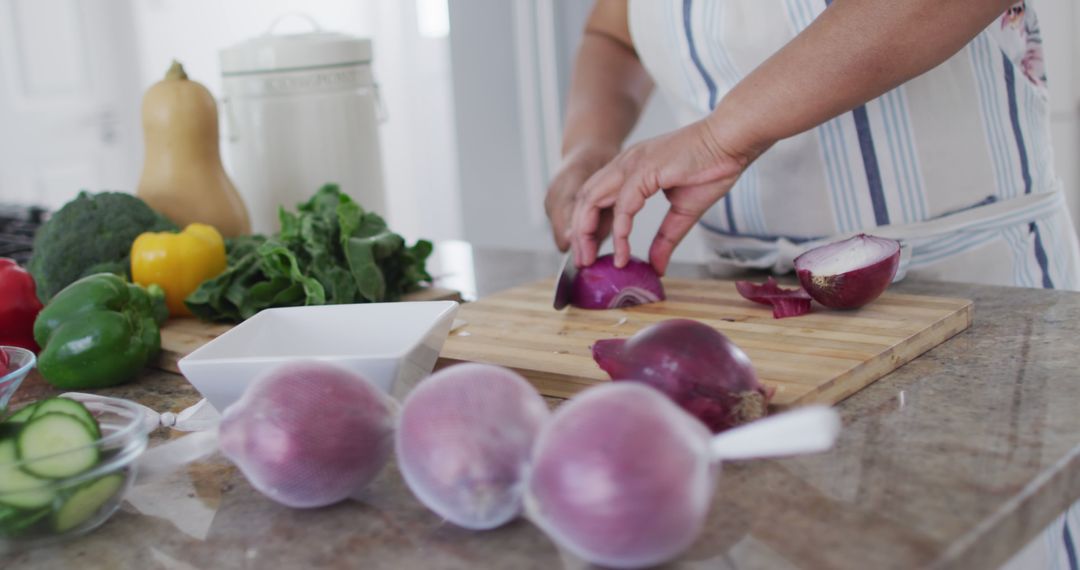 Hands Chopping Red Onion with Variety of Fresh Vegetables on Kitchen Counter - Free Images, Stock Photos and Pictures on Pikwizard.com