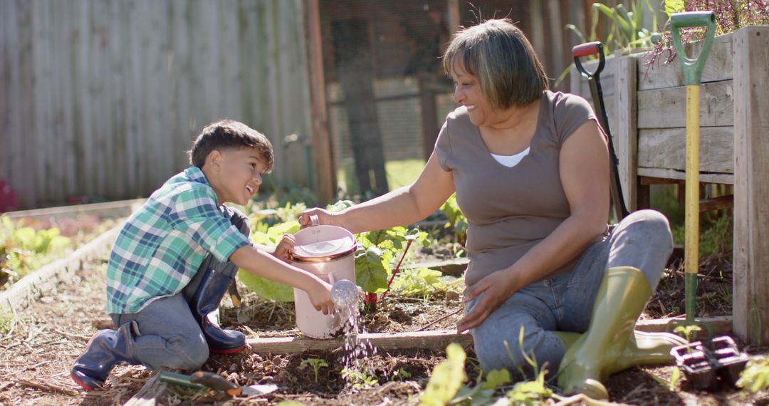 Happy senior biracial grandmother and grandson watering plants in sunny garden - Free Images, Stock Photos and Pictures on Pikwizard.com