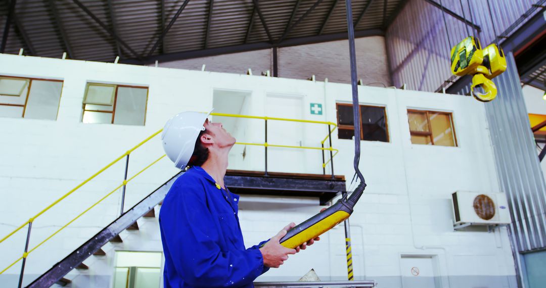 Factory Worker Controlling Overhead Crane with Remote - Free Images, Stock Photos and Pictures on Pikwizard.com