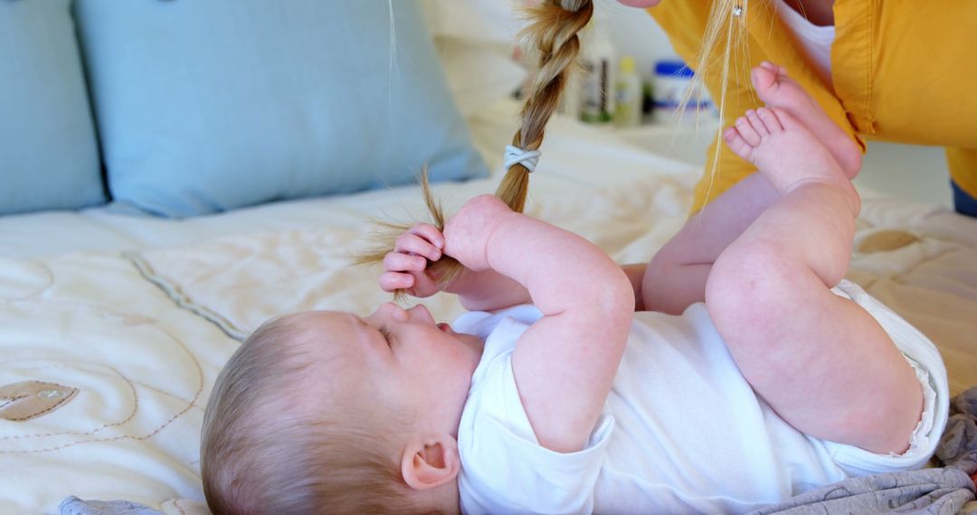 Baby Playing with Mother's Hair While Lying on Bed - Free Images, Stock Photos and Pictures on Pikwizard.com