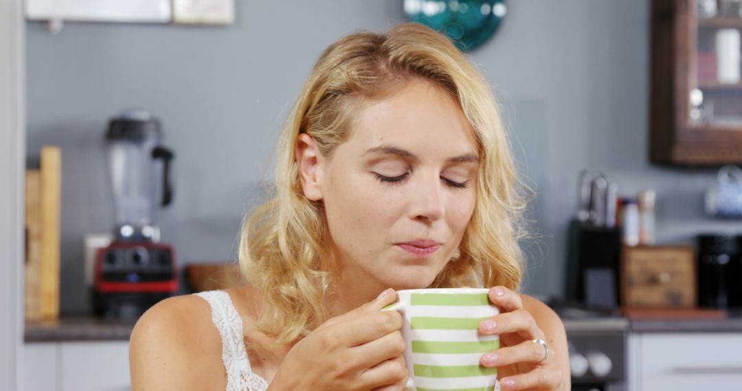 Relaxed Woman Enjoying Morning Coffee in Cozy Kitchen - Free Images, Stock Photos and Pictures on Pikwizard.com