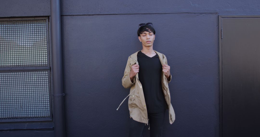 Young Asian Man Wearing Black Outfits Standing Against Dark Wall - Free Images, Stock Photos and Pictures on Pikwizard.com