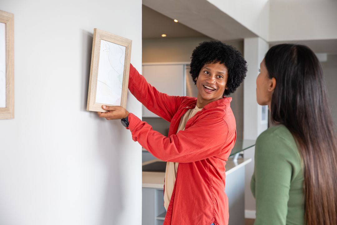 Couple Collaborating to Hang Artwork in Modern Home