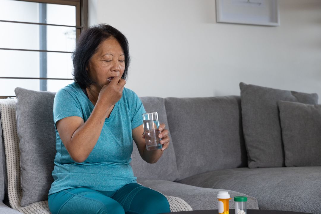 Elderly Woman Taking Medication at Home for Daily Health Routine