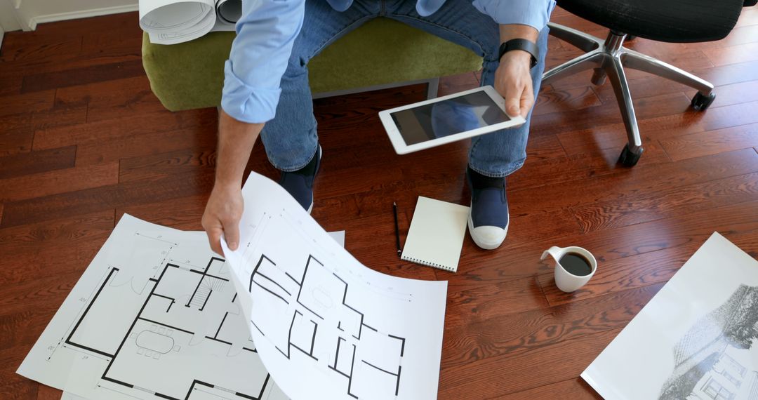 Male Architect Analyzing Floor Plans with Tablet in Home Office - Free Images, Stock Photos and Pictures on Pikwizard.com