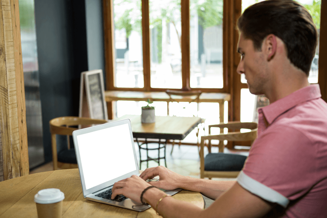 Man Using Transparent Laptop in Modern Cafe Setting