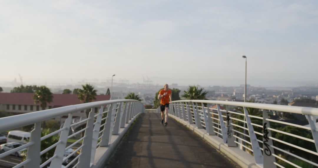 Male Runner Jogging on Urban Bridge in the Morning - Free Images, Stock Photos and Pictures on Pikwizard.com