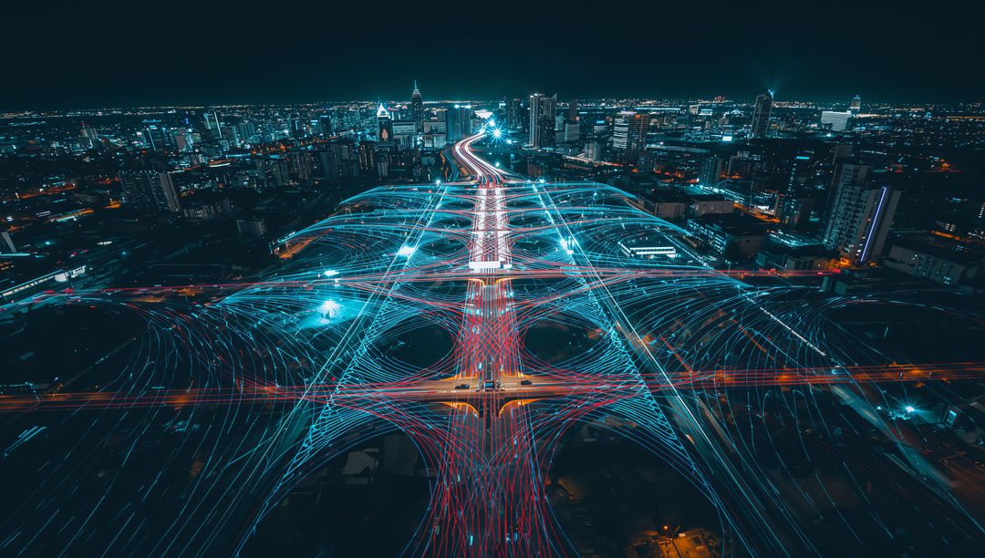 Multilane Interchange Curving through Neon Light Trails over City Night Skyline
