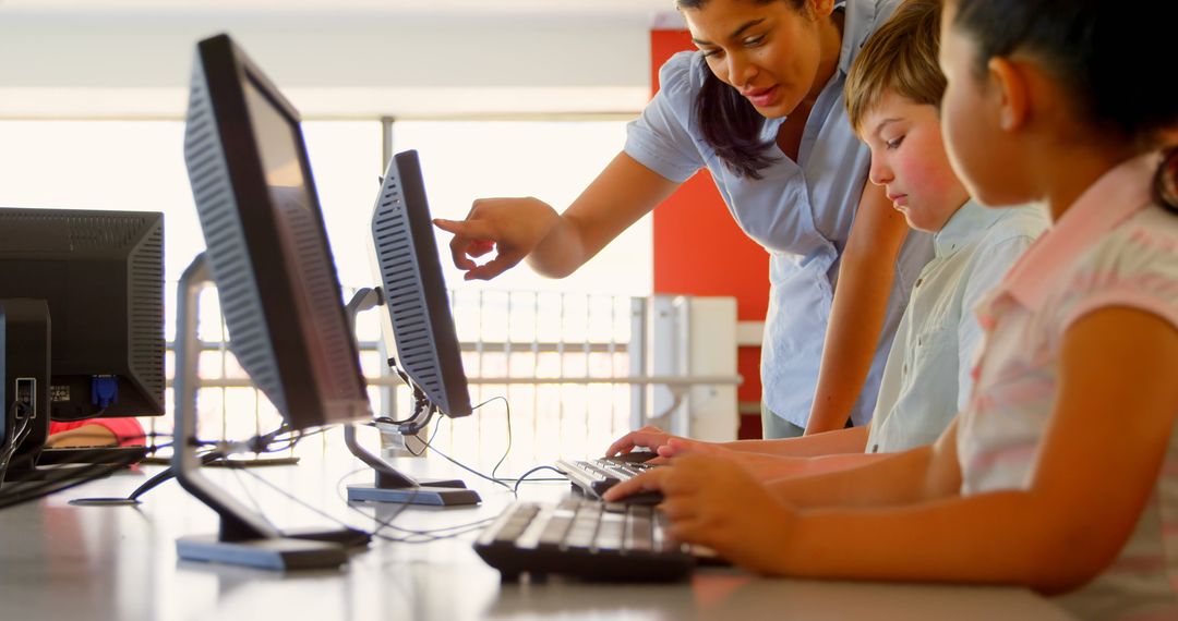 Teacher Guiding Young Students in Computer Lab Activity
