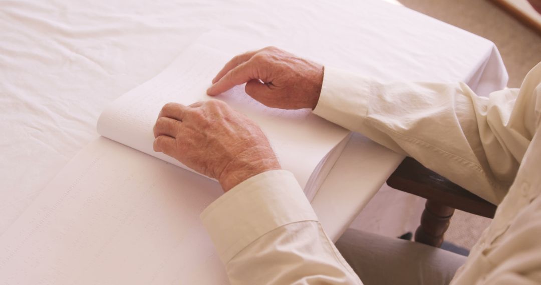 Elderly Person Reading Braille Book at Table - Free Images, Stock Photos and Pictures on Pikwizard.com