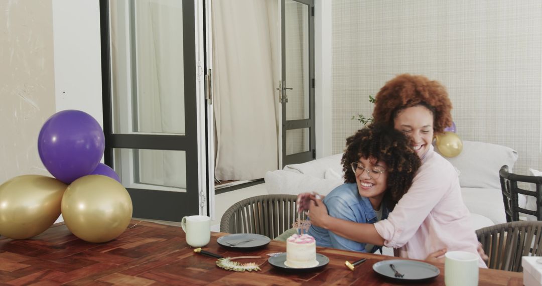 Loving couple hugging while celebrating birthday with cake and balloons